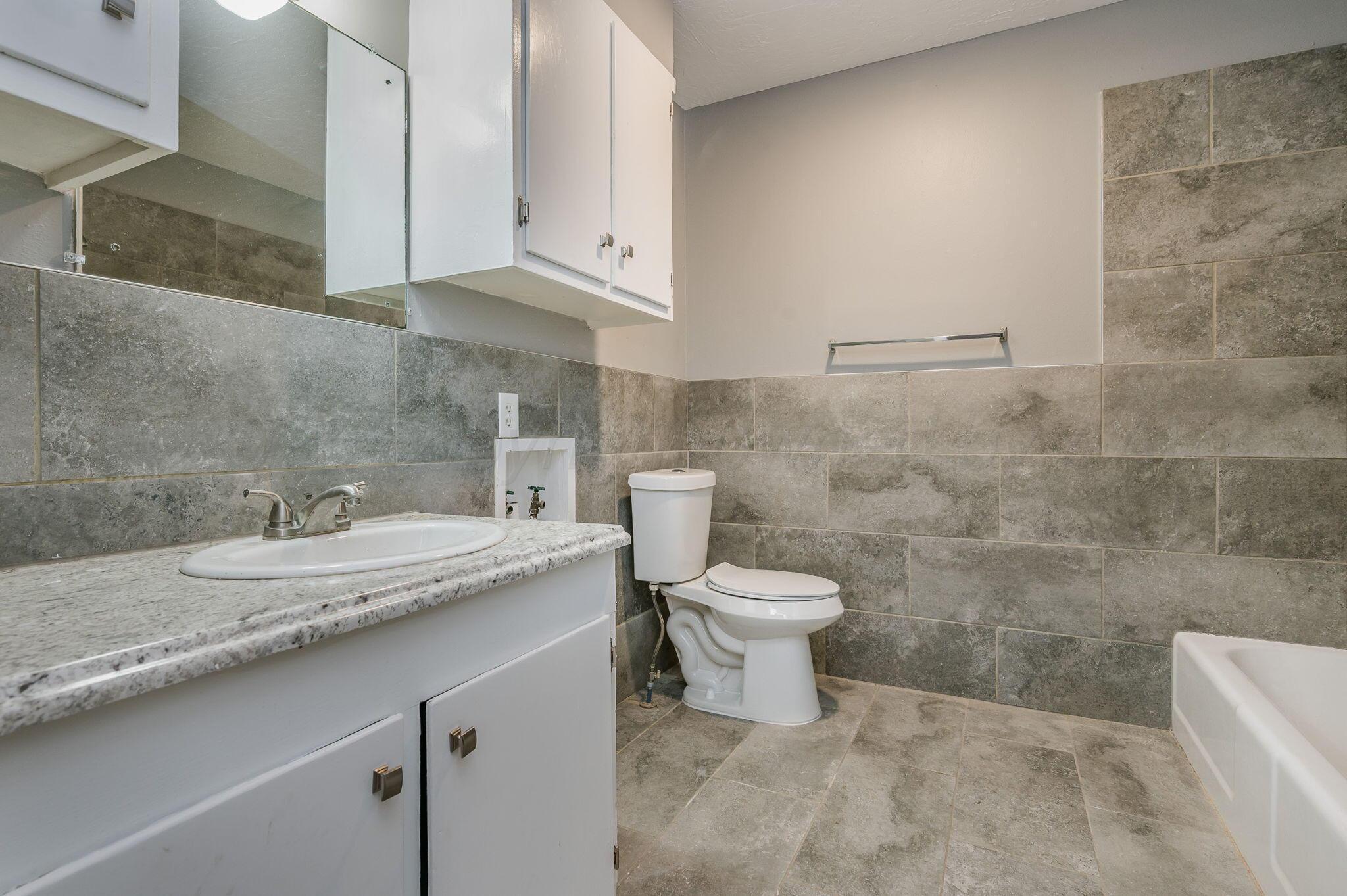 609 16th Street, Unit 3 Canyon, TX 79015 - Photo 13 of 15 a bathroom with a sink a toilet and a mirror