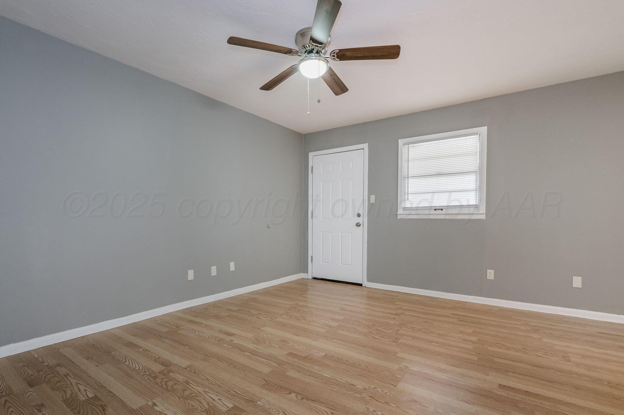 609 16th Street, Unit 3 Canyon, TX 79015 - Photo 3 of 15 wooden floor in an empty room with a window