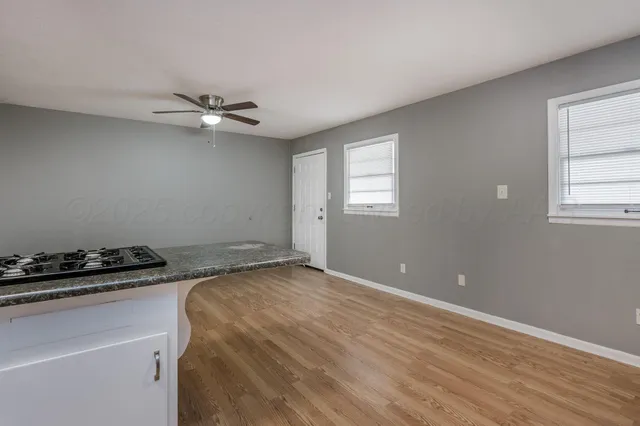 a kitchen with stainless steel appliances a refrigerator a stove a sink and white cabinets