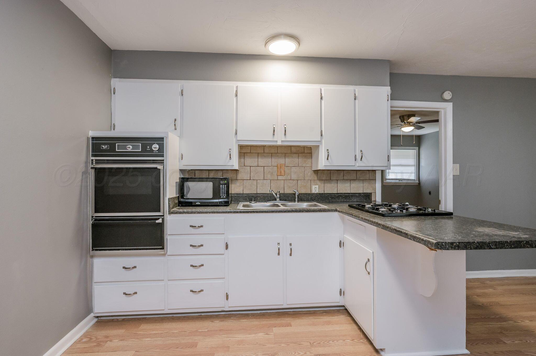 609 16th Street, Unit 3 Canyon, TX 79015 - Photo 8 of 15 a kitchen with granite countertop white cabinets and stainless steel appliances