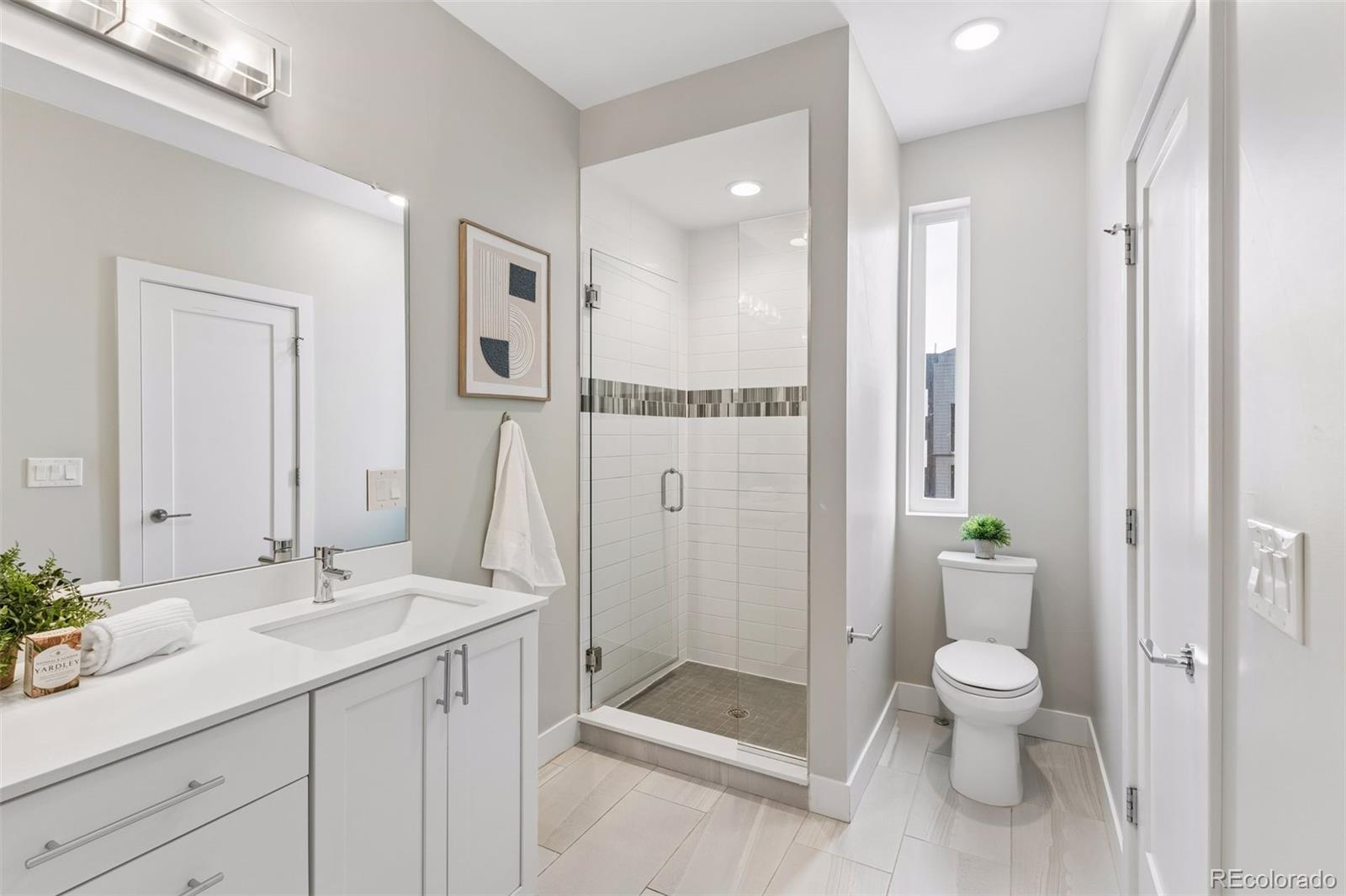 1235 Perry Street Denver, CO 80204 - Photo 23 of 41 a bathroom with a shower sink vanity mirror and toilet