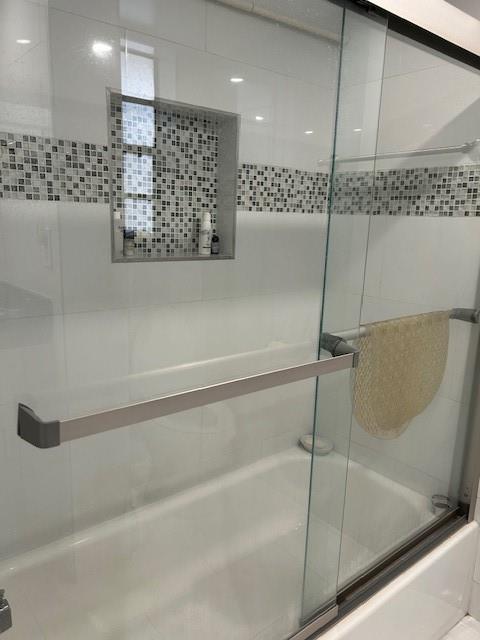 3590 Blue Lake Drive, Unit 305 Pompano Beach, FL 33064 - Photo 9 of 23 a bathroom with a bathtub and a shower