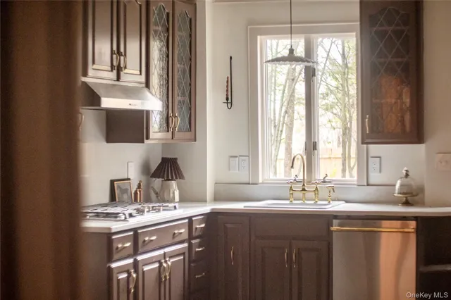 a kitchen with kitchen island granite countertop a sink appliances and cabinets