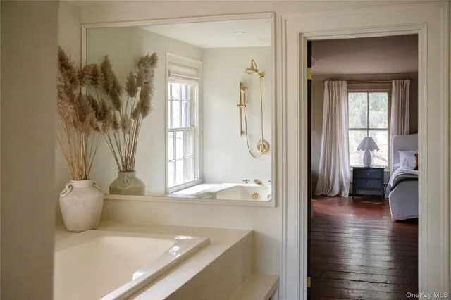 a view of a bathroom with a tub shower and mirror