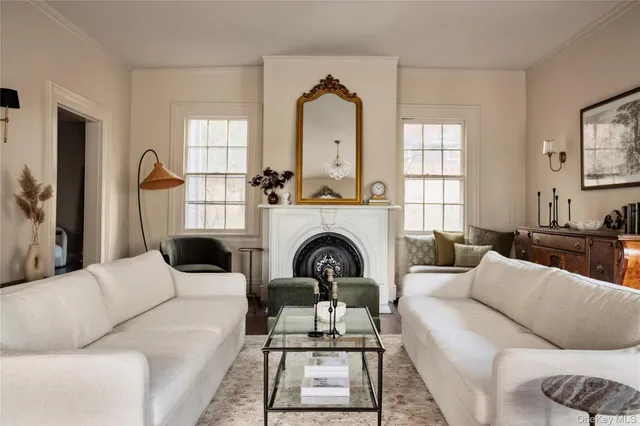 a living room with furniture a fireplace and a large mirror