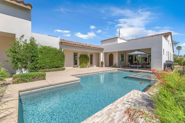 a view of a house with pool and a yard