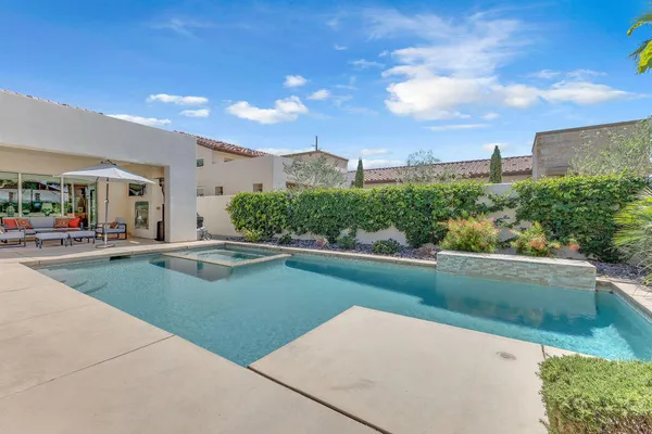 a swimming pool with outdoor seating and plants