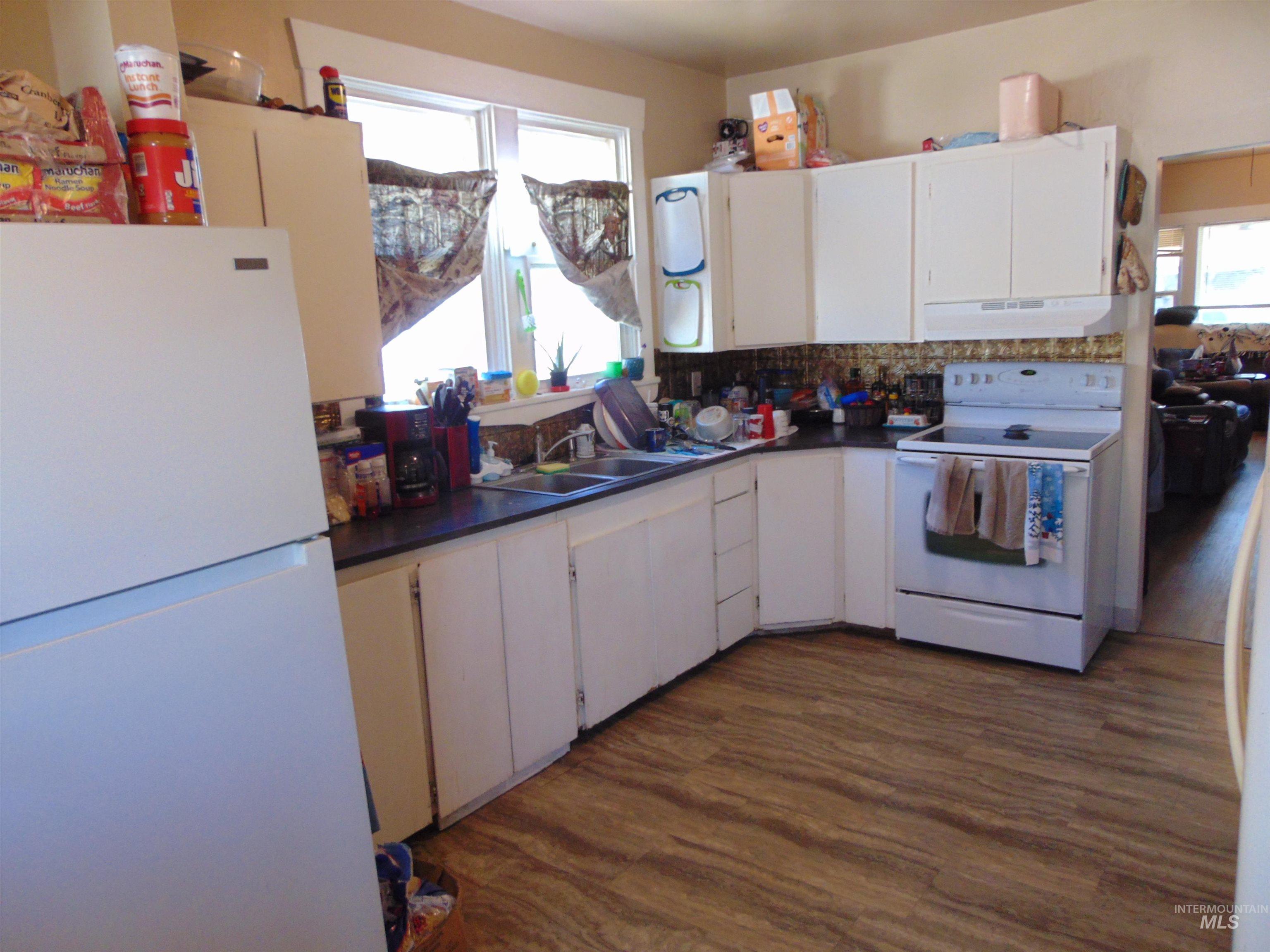 1437 Idaho Street Lewiston, ID 83501 - Photo 4 of 14 Kitchen featuring white appliances, dark countertops, and dark wood finished floors