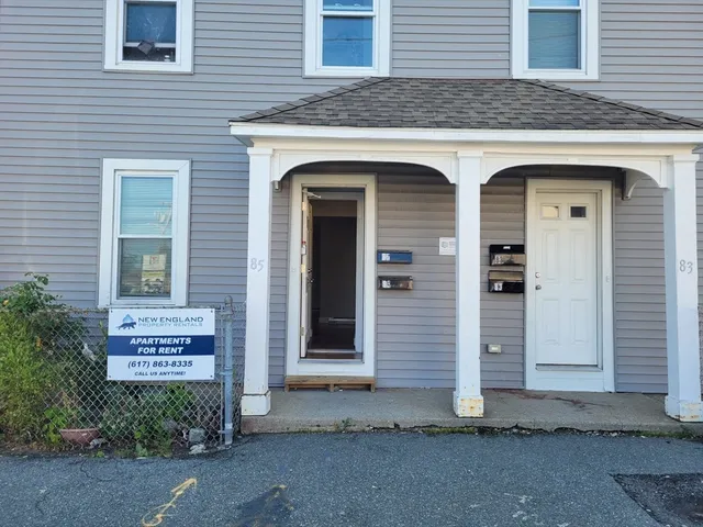 a view of a brick house with potted plants