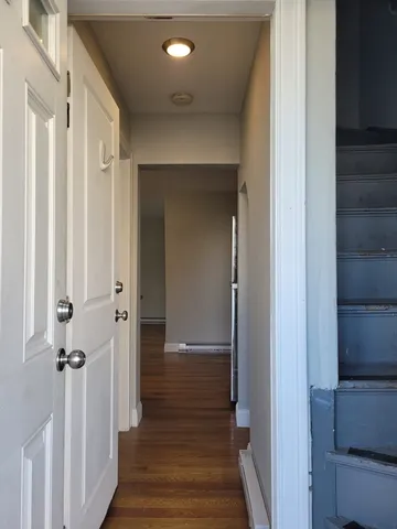 a view of a hallway with wooden floor and staircase