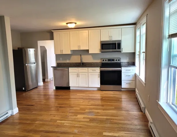 a kitchen with stainless steel appliances granite countertop a stove and a refrigerator