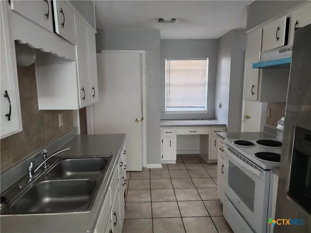 a kitchen that has a sink and a stove in it