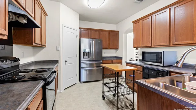a kitchen with stainless steel appliances granite countertop a stove refrigerator sink and cabinets
