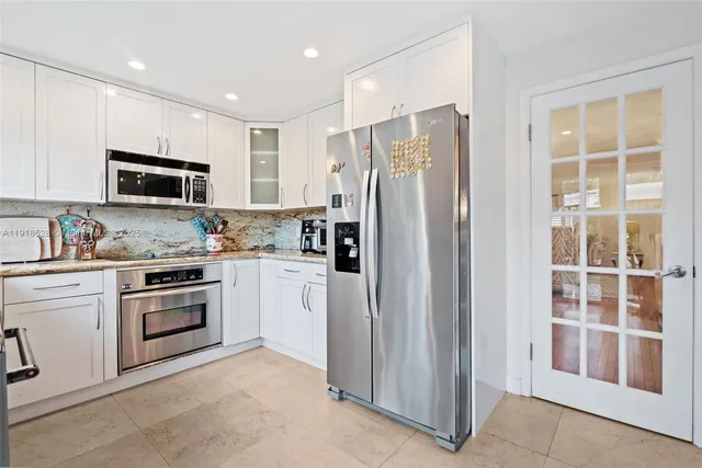 a kitchen with stainless steel appliances granite countertop a refrigerator and a stove top oven
