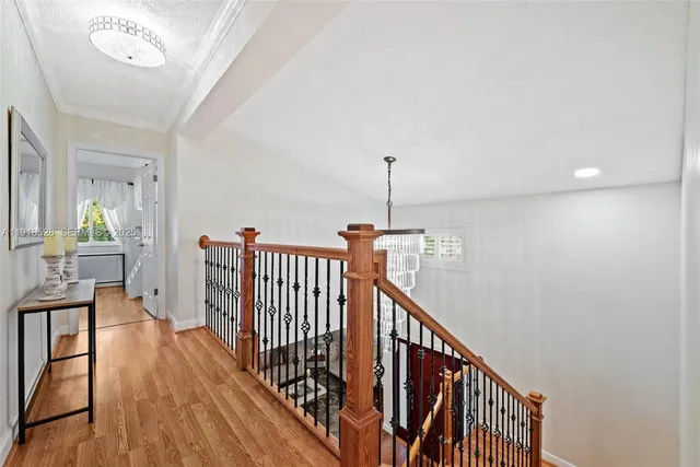 a view of a hallway with wooden floor and stairs