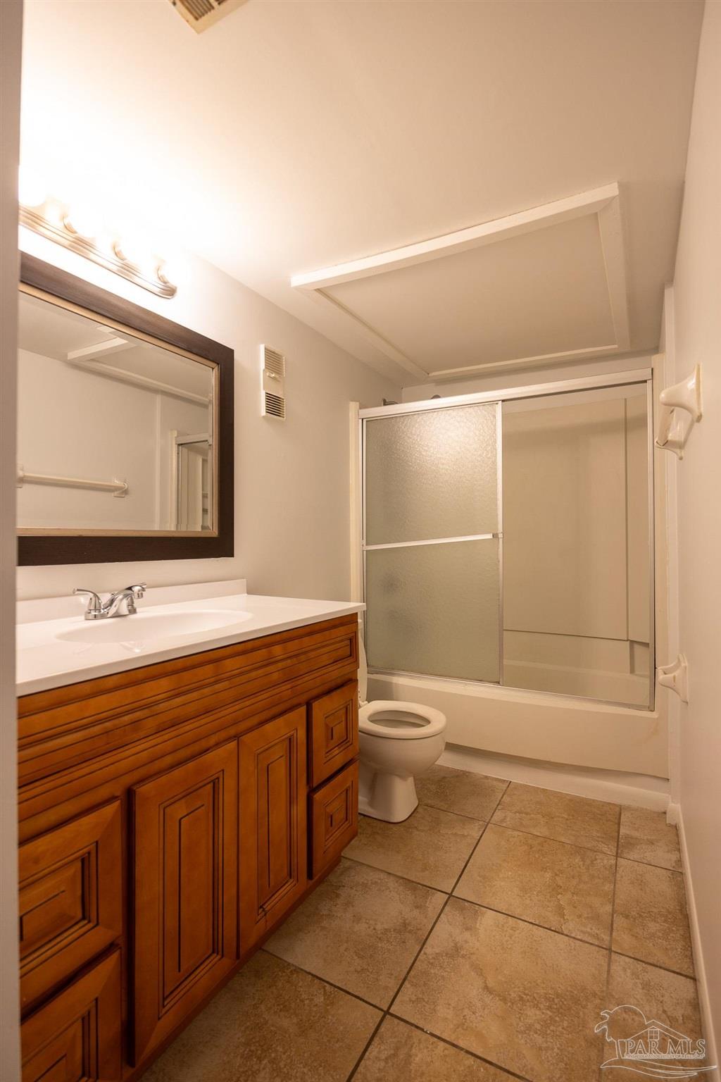 7150 Plantation Road, Unit 312 Pensacola, FL 32504 - Photo 7 of 14 a bathroom with a sink a toilet and mirror