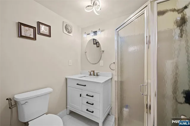 a bathroom with a toilet sink vanity and mirror