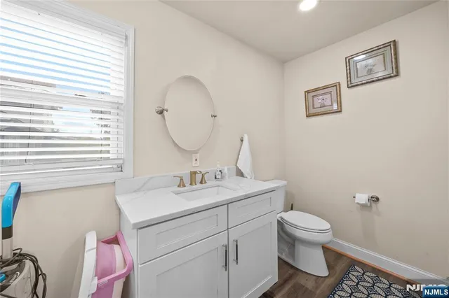 a bathroom with a toilet sink vanity and mirror