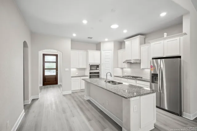 a kitchen with a refrigerator a sink and wooden cabinets