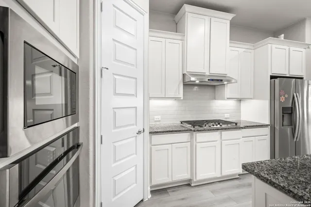 a kitchen with cabinets and stainless steel appliances