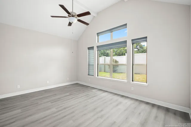 an empty room with wooden floor and windows