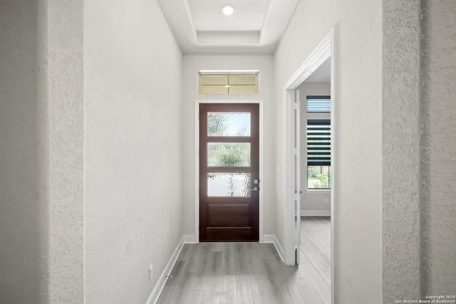 a view of a hallway with wooden floor and a living room