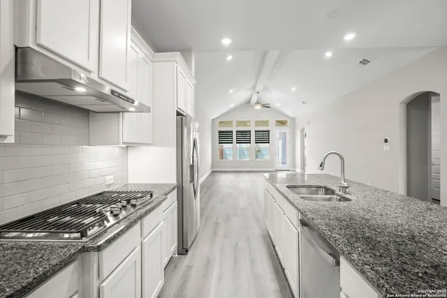 a kitchen with kitchen island a sink stove and cabinets