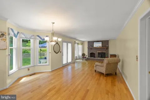 a view of a livingroom with wooden floor and kitchen
