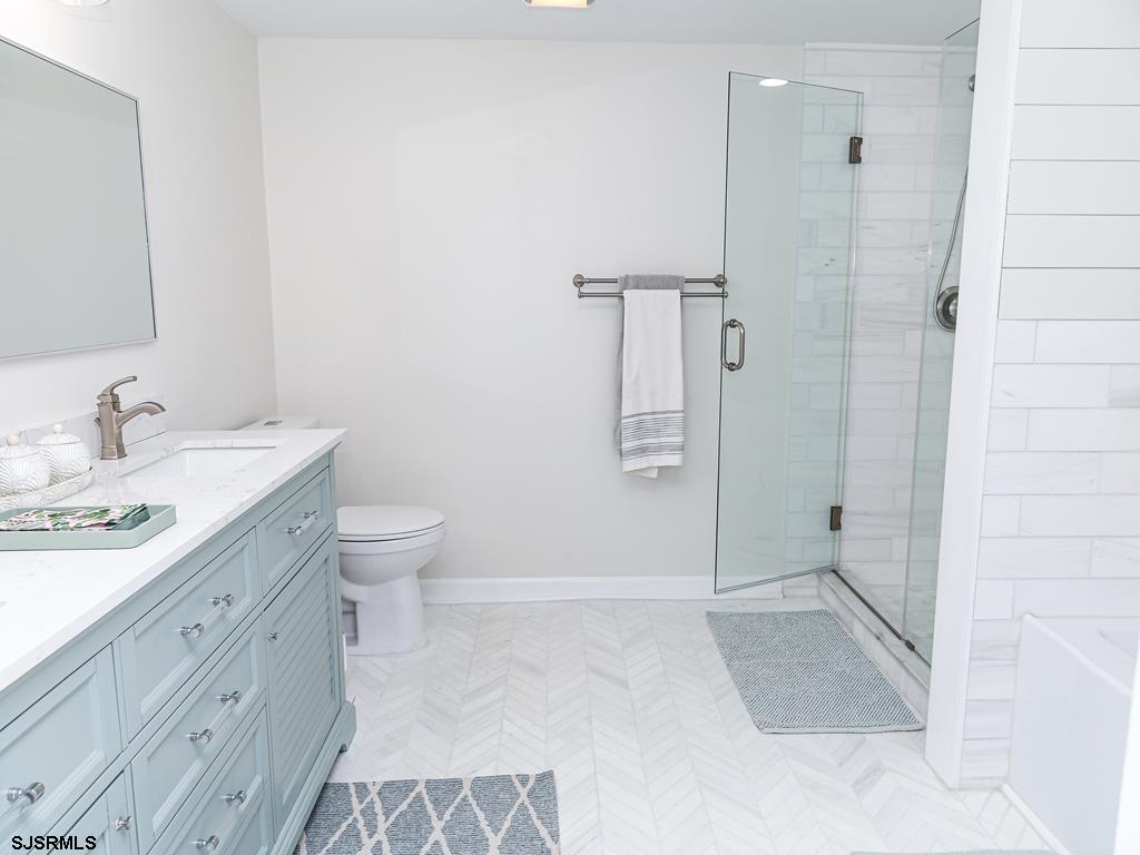 3901 Ocean Avenue, Unit 1 Brigantine, NJ 08203 - Photo 21 of 30 a spacious bathroom with a double vanity sink toilet mirror and shower