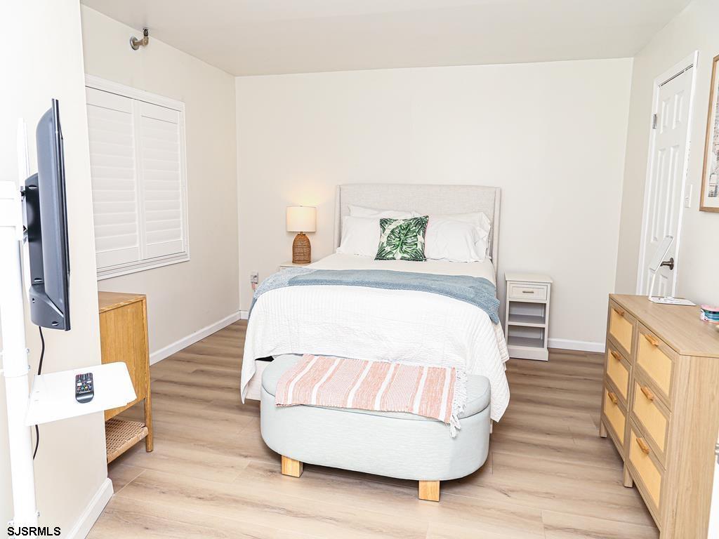 3901 Ocean Avenue, Unit 1 Brigantine, NJ 08203 - Photo 23 of 30 a spacious bedroom with a bed and wooden floor