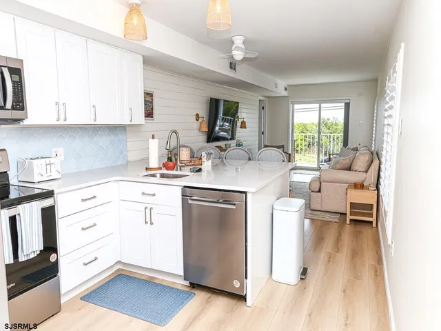 a kitchen with a refrigerator stove and white cabinets