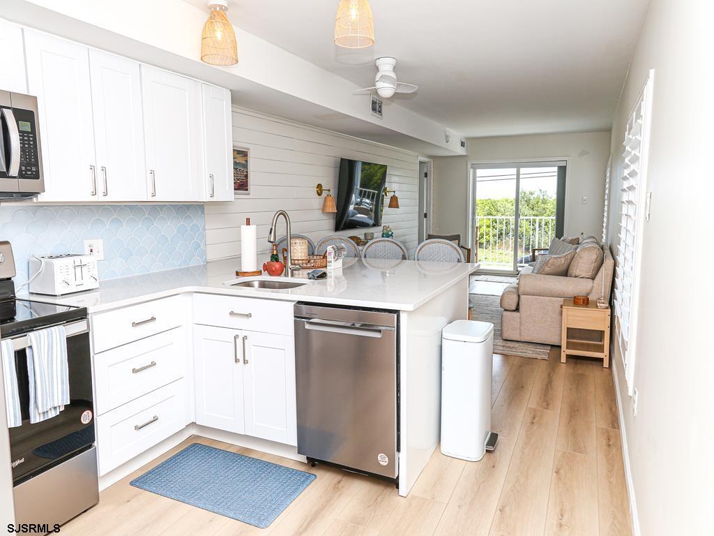 3901 Ocean Avenue, Unit 1 Brigantine, NJ 08203 - Photo 9 of 30 a kitchen with a refrigerator stove and white cabinets