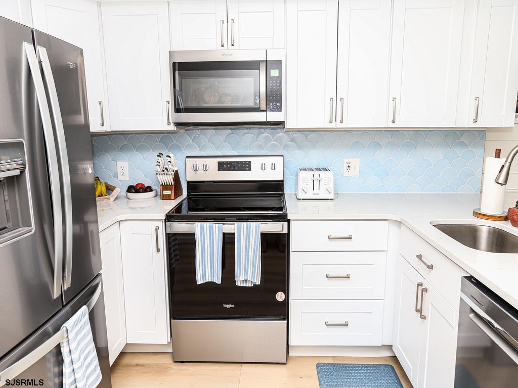 3901 Ocean Avenue, Unit 1 Brigantine, NJ 08203 - Photo 10 of 30 a kitchen with stainless steel appliances granite countertop a refrigerator stove and microwave