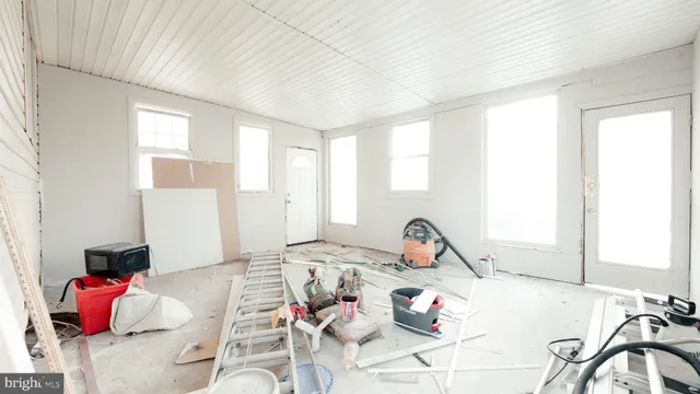 an empty room with wooden floor and white walls