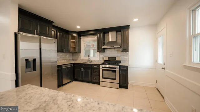 a kitchen with stainless steel appliances granite countertop a stove a refrigerator and a sink