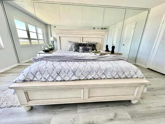 a bedroom with a bed and wooden floor