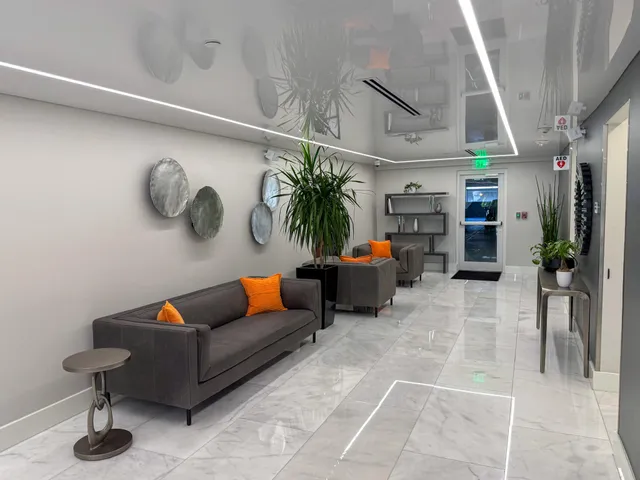 a living room with furniture a rug and a wall painting