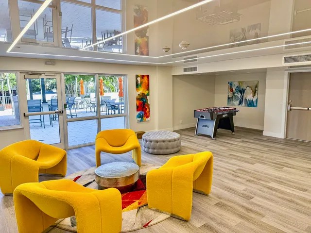 a living room with patio furniture and a floor to ceiling window