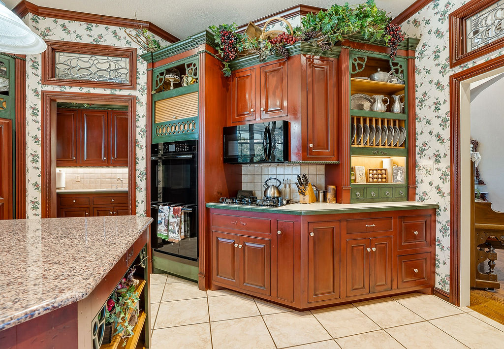 1009 Southeast County Road Ada, OK 74820 - Photo 19 of 92 Custom cabinetry with integrated plate rack, built-in microwave, double oven, and tile flooring