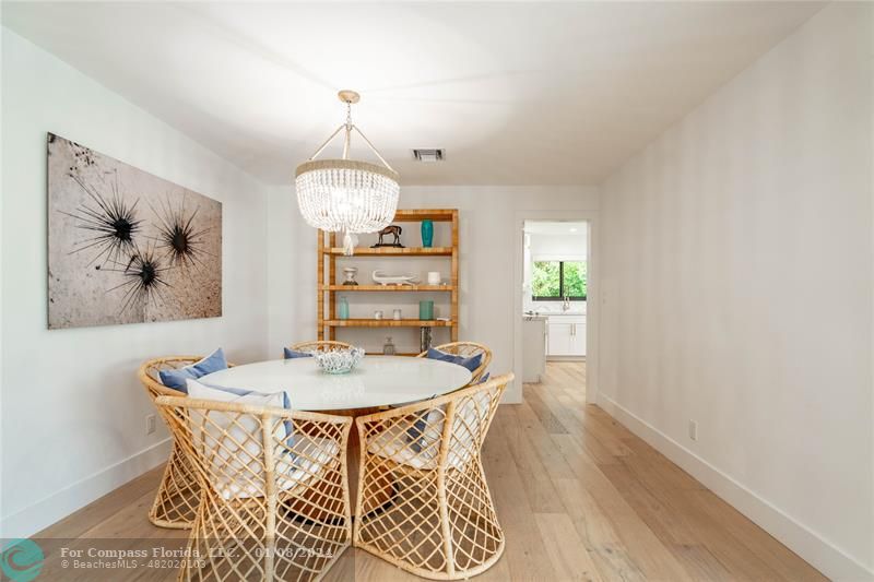 2375 Northeast 29th Street Lighthouse Point, FL 33064 - Photo 16 of 76 a dining room with wooden floor a chandelier a wooden table and chairs