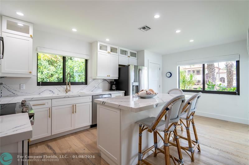 2375 Northeast 29th Street Lighthouse Point, FL 33064 - Photo 17 of 76 a kitchen with a table chairs sink and cabinets