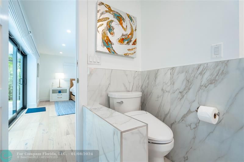 2375 Northeast 29th Street Lighthouse Point, FL 33064 - Photo 29 of 76 a bathroom with a toilet and a shower curtain