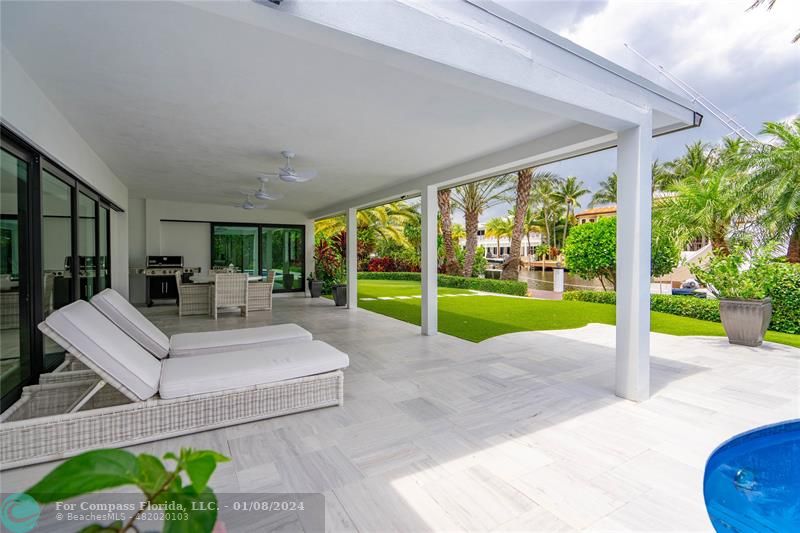2375 Northeast 29th Street Lighthouse Point, FL 33064 - Photo 49 of 76 a view of a patio with table and chairs potted plants and floor to ceiling window