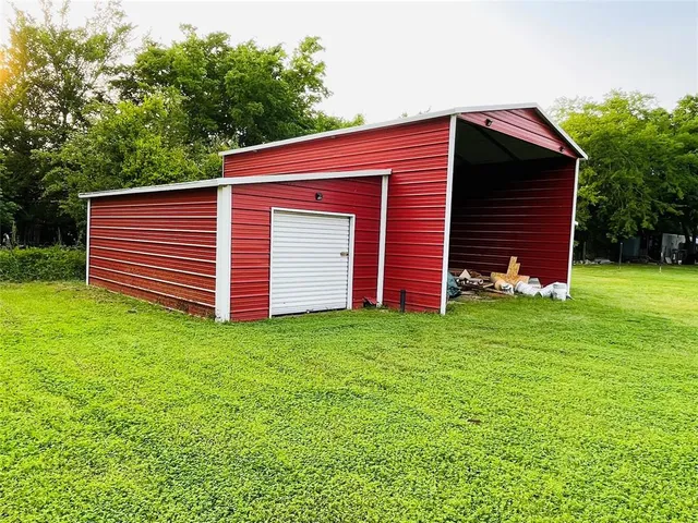 a view of a backyard with potted plants and large tree