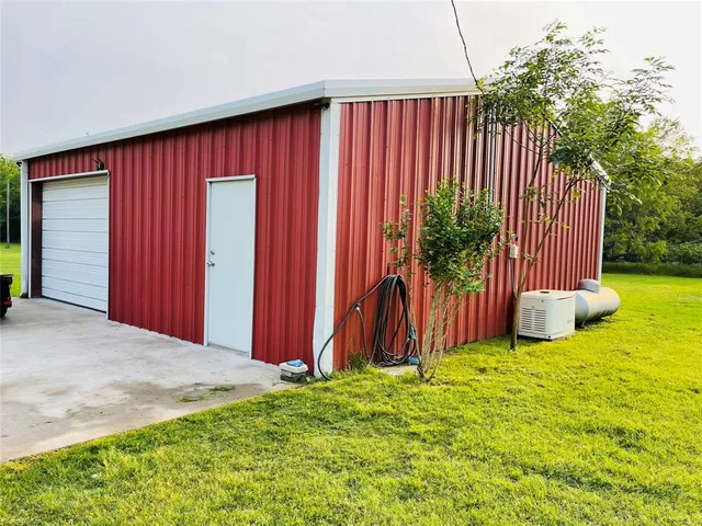 a view of a backyard with potted plants and large tree