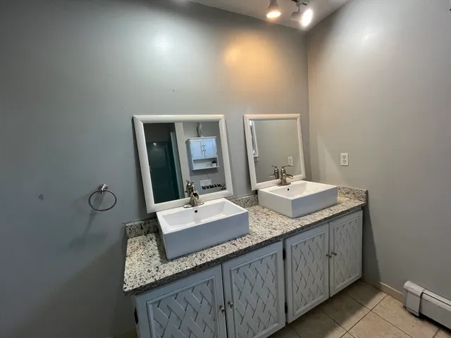 a bathroom with a granite countertop sink and a mirror