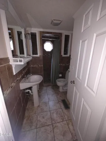 a bathroom with a sink a toilet a mirror and vanity