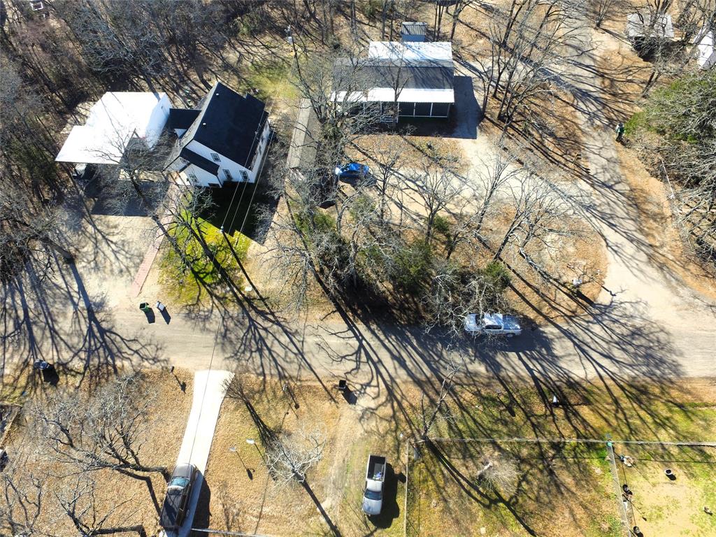 Tbd Live Oak Street Quinlan, TX 75474 - Photo 7 of 16 a backyard of a house with table and chairs under an umbrella