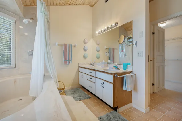 a spacious bathroom with a double vanity sink a mirror and a shower