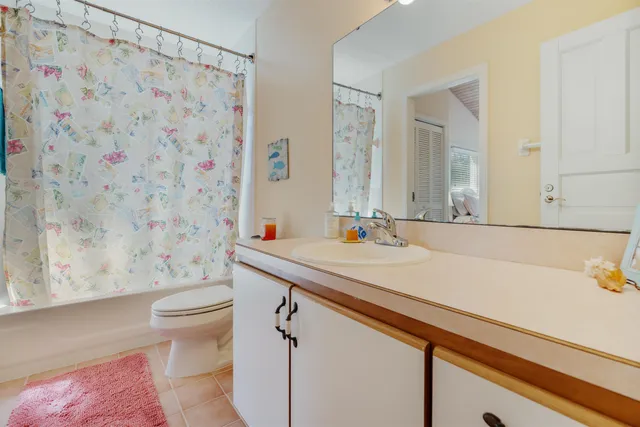 a bathroom with a sink a toilet and a shower curtain